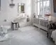 Helles Badezimmer mit elegantem Design, ausgestattet mit WC und Waschbecken, Fenster mit Blick ins Freie. Ideal Standard Produkte wurden verwendet. Chandelier und dekorative Elemente unterstreichen den Stil.